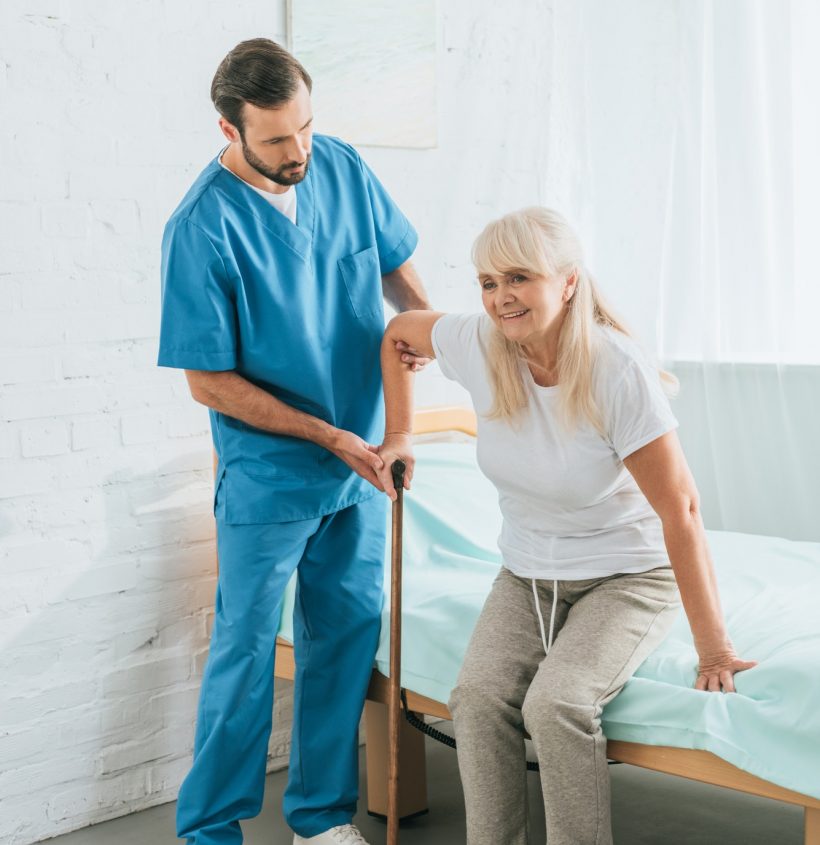 male-nurse-helping-senior-woman-with-walking-stick.jpg